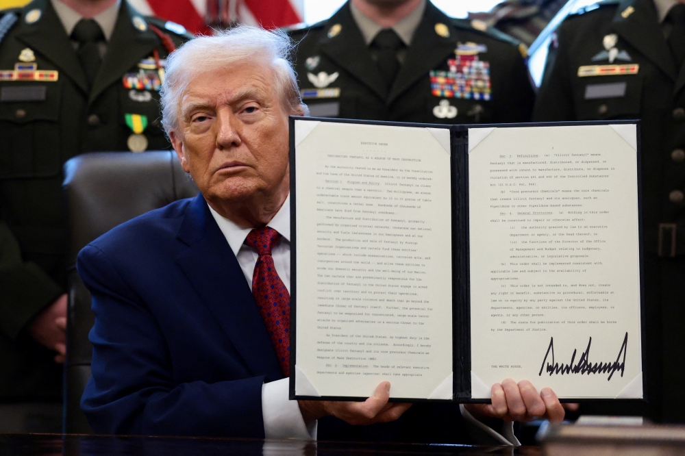 US President Donald Trump shows a signed executive order classifying fentanyl as ‘weapon of mass destruction’ during a Mexican Border Defence Medal presentation in the Oval Office at the White House in Washington, DC December 15, 2025. — Reuters pic