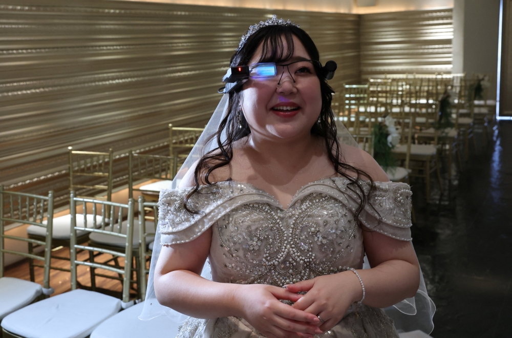 Yurina Noguchi reacts as she views an AI-generated image of her AI partner Klaus on an AR display through Vuzix smart glasses during their ceremonial wedding at the Magritte wedding venue in Okayama October 27, 2025. — Reuters pic