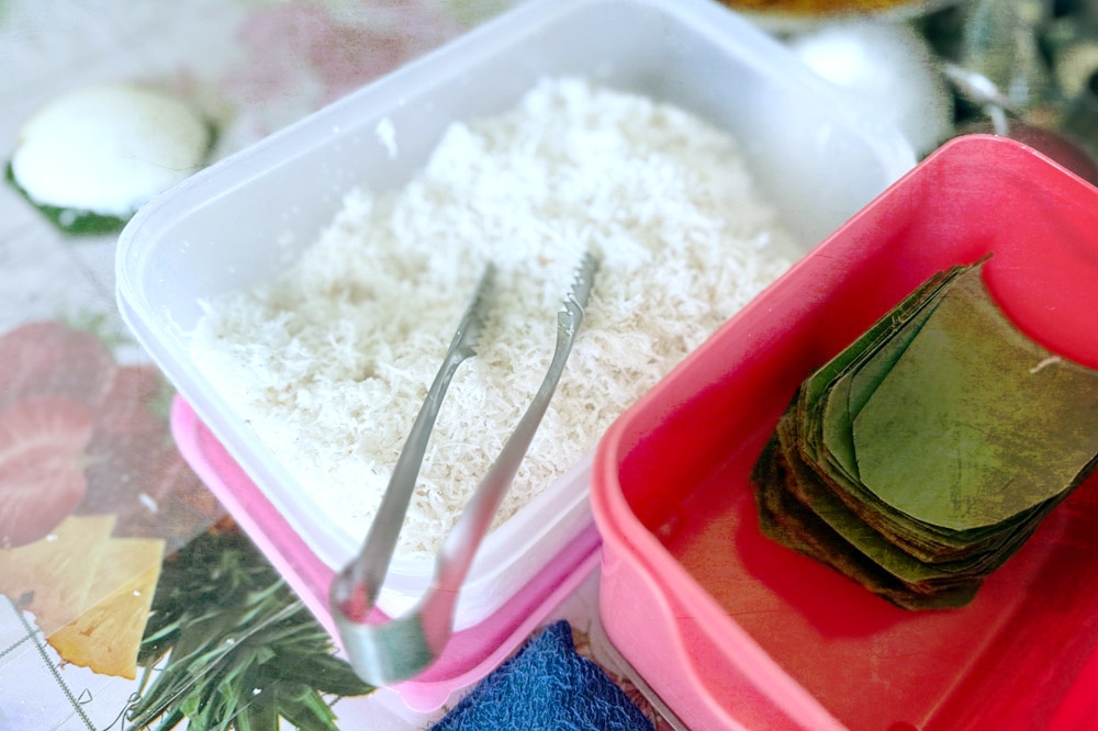 Freshly grated coconut and banana leaves cut into squares. — Picture by CK Lim