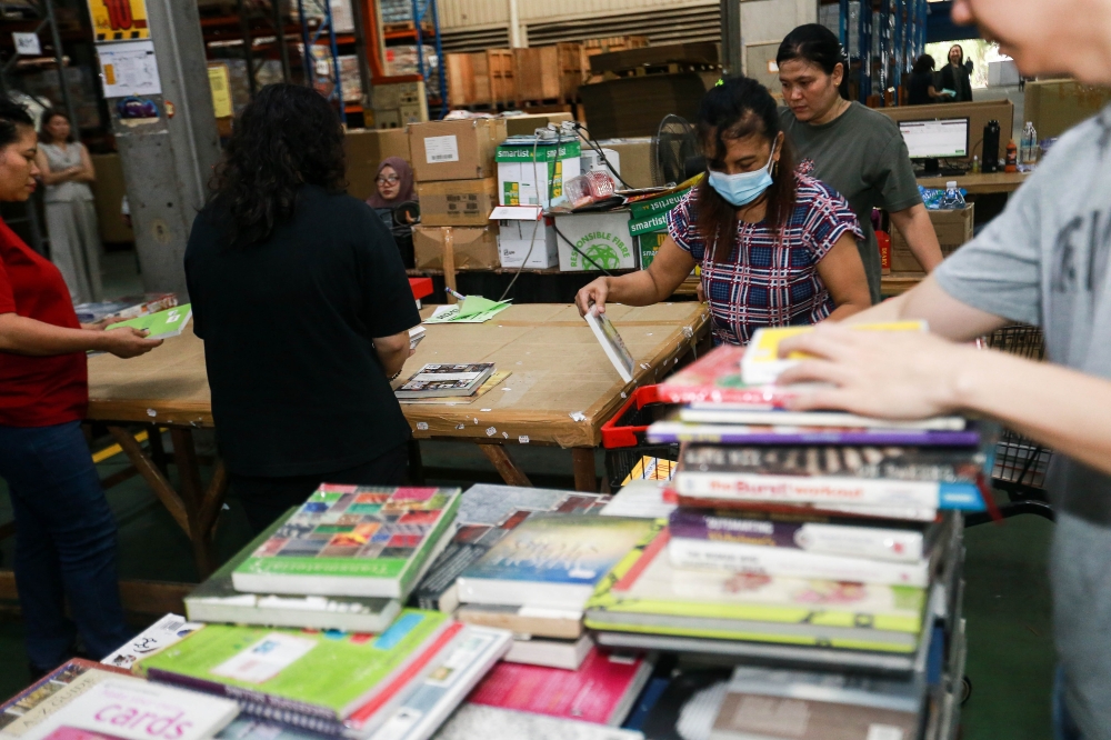 Warehouse staff check books as they prepare for the next event during the BookXcess X Big Bad Wolf Media Warehouse tour at Wolf House, Shah Alam. — Picture by Sayuti Zainudin