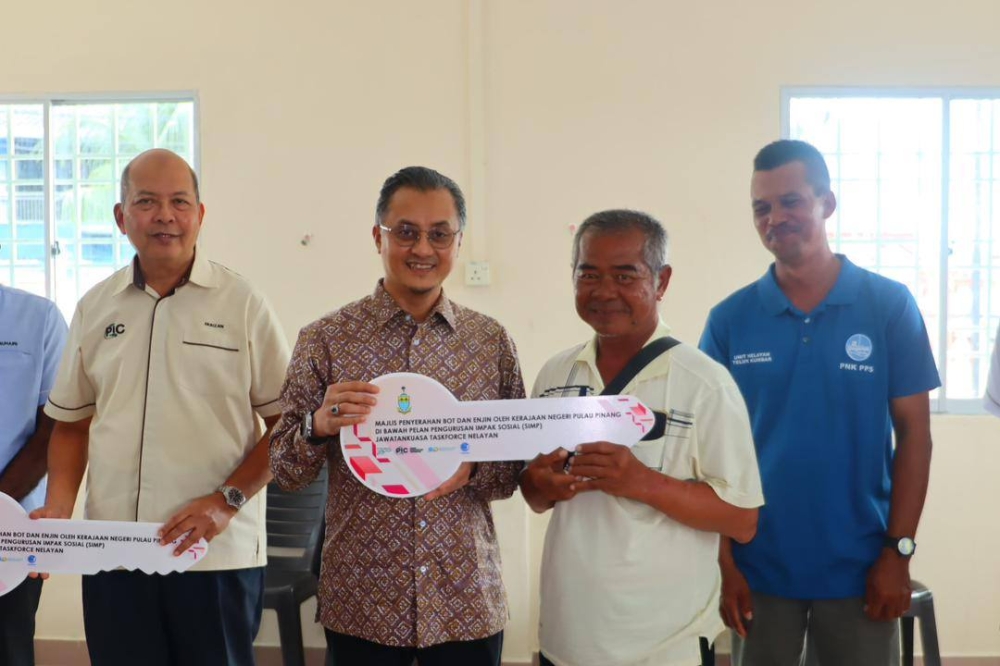 Penang Deputy Chief Minister I Datuk Mohamad Abdul Hamid (second from left) hands over a mock key to represent aid to 127 fishermen directly impacted by the Silicon Island project on December 17, 2025. — Picture from Facebook/Dato’ Dr Mohamad Abdul Hamid