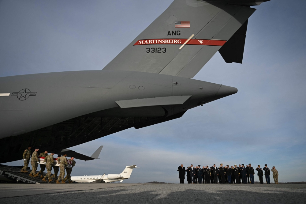US President Donald Trump and US Secretary of Defence Pete Hegseth salute as a US Army carry team moves the transfer case containing the remains of US Army Sgt. William Howard, during the dignified transfer of the remains of two Iowa National Guard members killed in an attack in Syria during a ceremony at Dover Air Force Base in Delaware on December 17, 2025. — AFP pic
