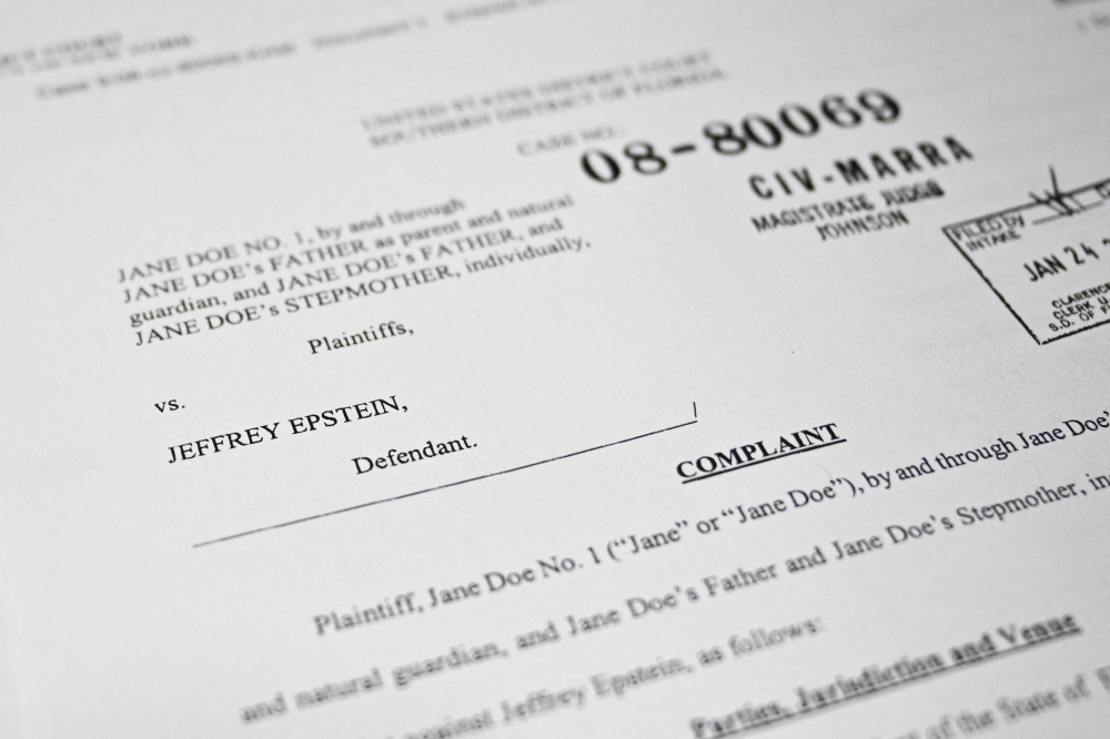 This photo illustration taken in Washington, DC, on December 19, 2025 shows a court document after the US Justice Department began releasing the long-awaited records from the investigation into the politically explosive case of convicted sex offender Jeffrey Epstein. — AFP pic 