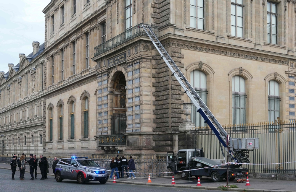 French police officers stand next to a furniture elevator used by robbers to enter the Louvre Museum, on Quai Francois Mitterrand, in Paris October 19, 2025. — AFP pic