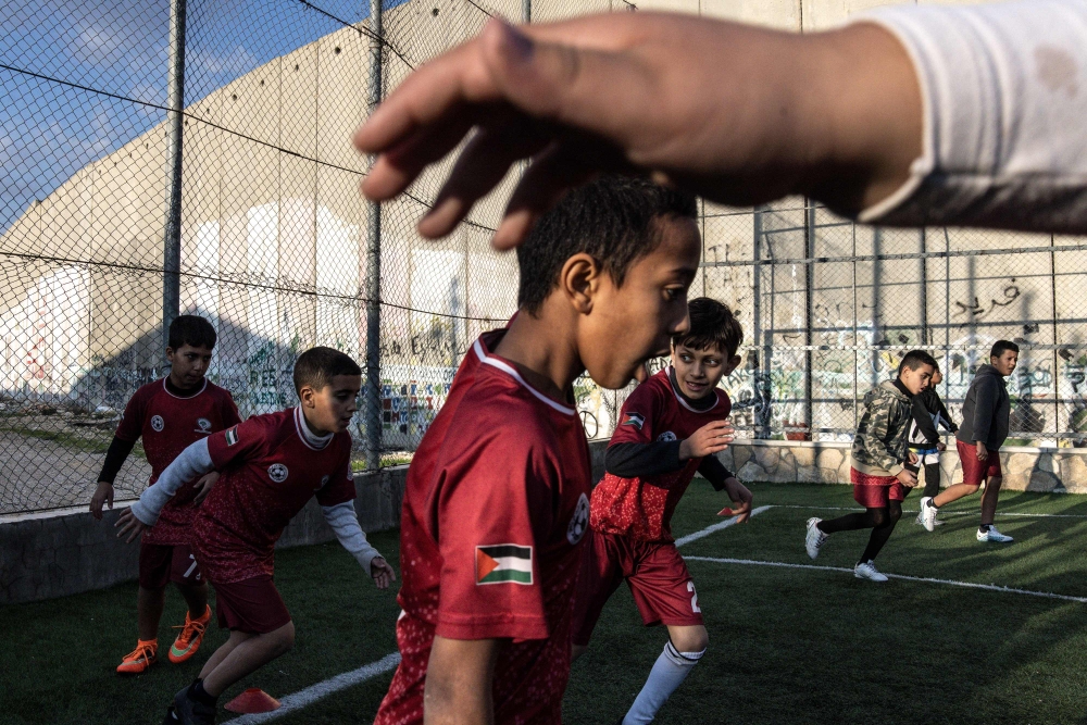 Displaced Palestinian youths take part in a training session at the Aida Refugee Camp football pitch, next to the separation wall outside Bethlehem in the occupied West Bank, December 16, 2025, a few weeks after an Israeli military decision to demolish the field. — AFP pic