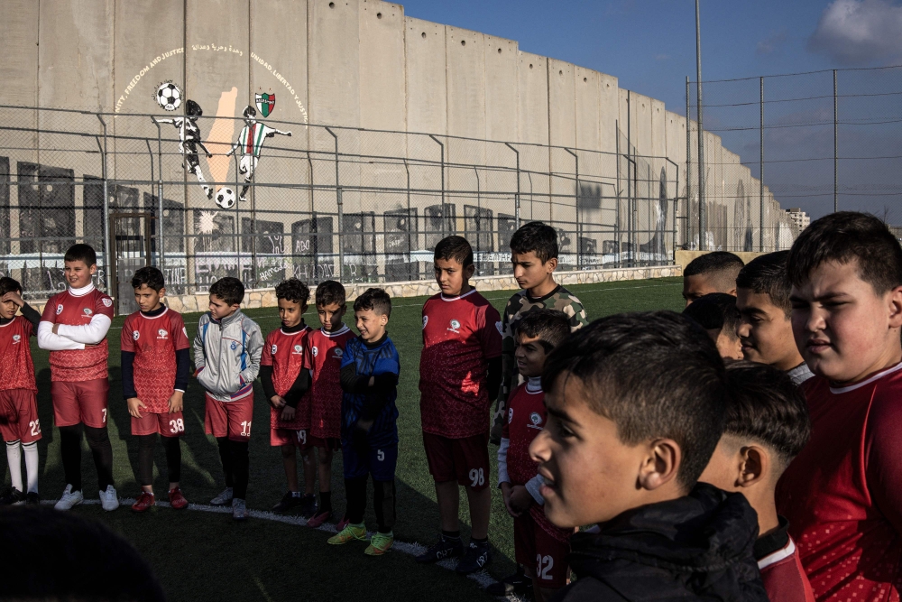 Displaced Palestinian youths take part in a training session at the Aida Refugee Camp football pitch, next to the separation wall outside Bethlehem in the occupied West Bank, December 16, 2025, a few weeks after an Israeli military decision to demolish the field. — AFP pic