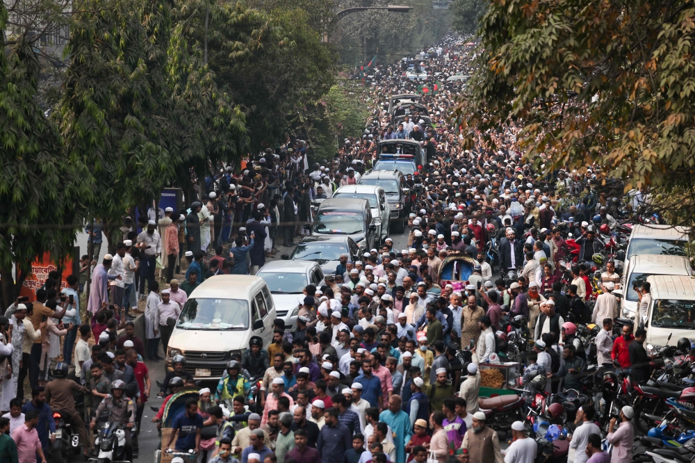 Bangladeshis rally along a vehicle carrying the body of youth leader Sharif Osman Hadi, as the deceased is taken for burial in Dhaka December 20, 2025. — AFP pic