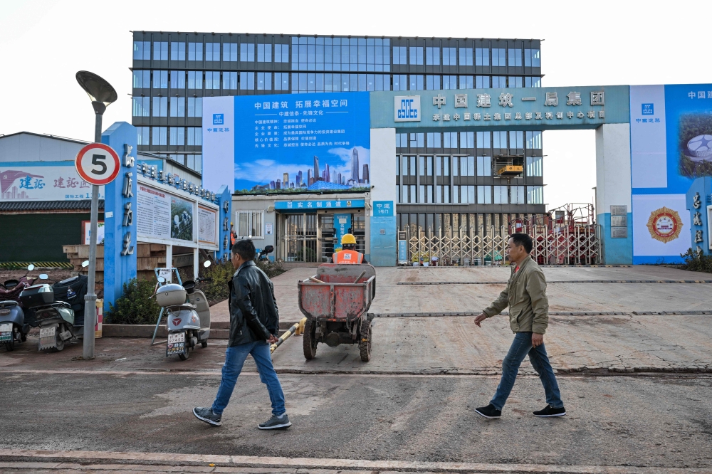 In this photo taken on November 21, 2025, construction workers are seen at the site of the new headquarters of the China Rare Earth Group in Ganzhou, in eastern China's Jiangxi province. — AFP pic