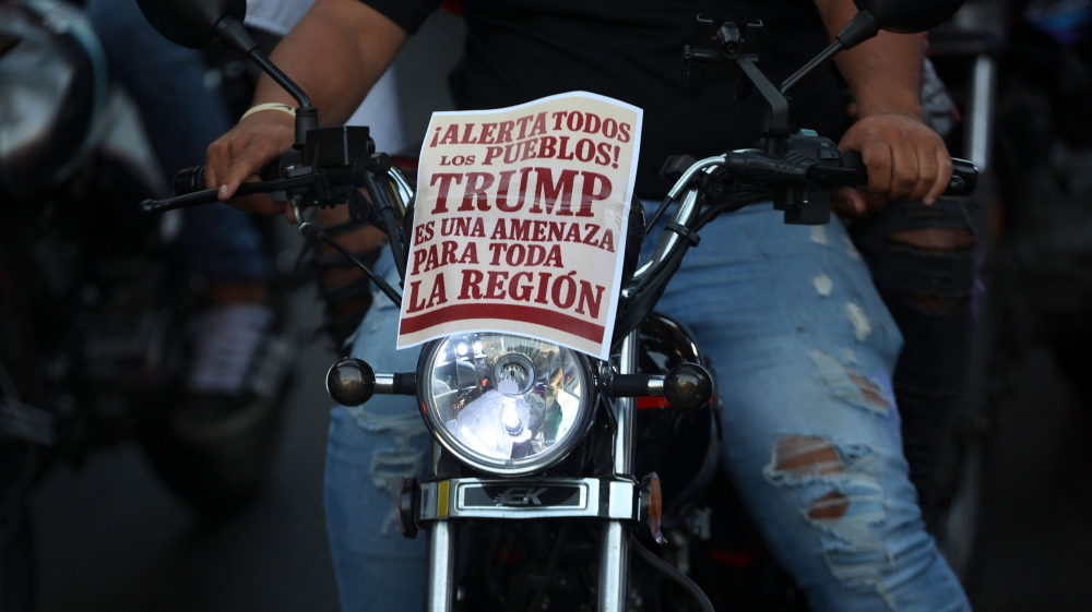 A motorcyclist carries a sign stating “Alert all peoples, Trump is a threat to the entire region” as demonstrators dressed as pirates ride through Caracas on December 22, 2025, to protest the United States’ seizure of ships carrying Venezuelan oil. — AFP pic