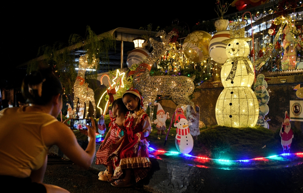 Visitors take photos at D. Charles’ home adorned with Christmas decorations in Taman Teluk Molek, Teluk Air Tawar, where he spent nearly RM25,000 on festive displays symbolising joy, harmony and multicultural unity. — Bernama pic