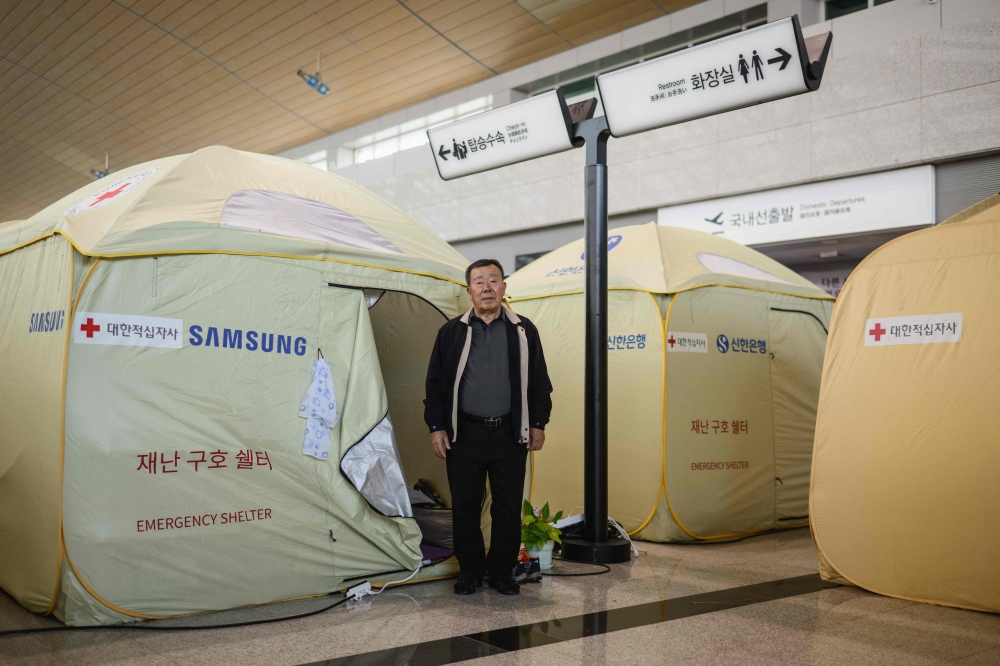 In this photo taken on December 14, 2025, Park In-wook poses in front of his tent at the departures hall of Muan International Airport, where he returns every weekend after he lost five loved ones; his wife, daughter, son-in-law and two young grandchildren, in the Jeju Air Flight 2216 plane crash on December 29, 2024. — AFP pic