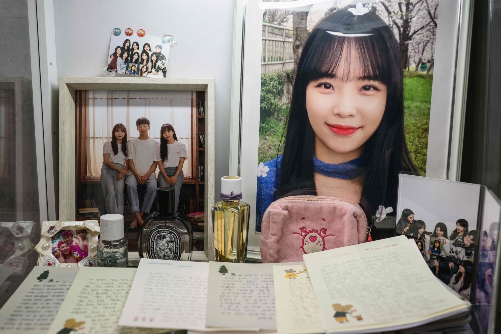 In this photo taken on December 14, 2025, family photos and letters written in memory of Ye-won (top R), a cello instructor, who had just celebrated her birthday and was returning from a short holiday in Bangkok on board the ill-fated Jeju Air Flight 2216 which crashed on December 29, 2024, are seen at her family home in Gwangju.