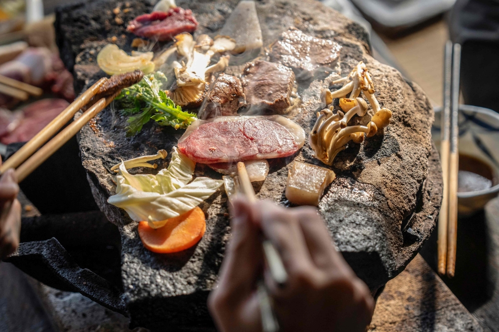 People cook bear meat and vegetables at a restaurant in Chichibu, Saitama prefecture, December 12, 2025. — AFP pic