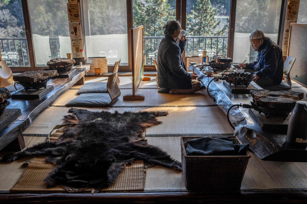 People eat next to a bear skin rug at a restaurant which offers bear meat in Chichibu, Saitama prefecture, December 12, 2025. — AFP pic