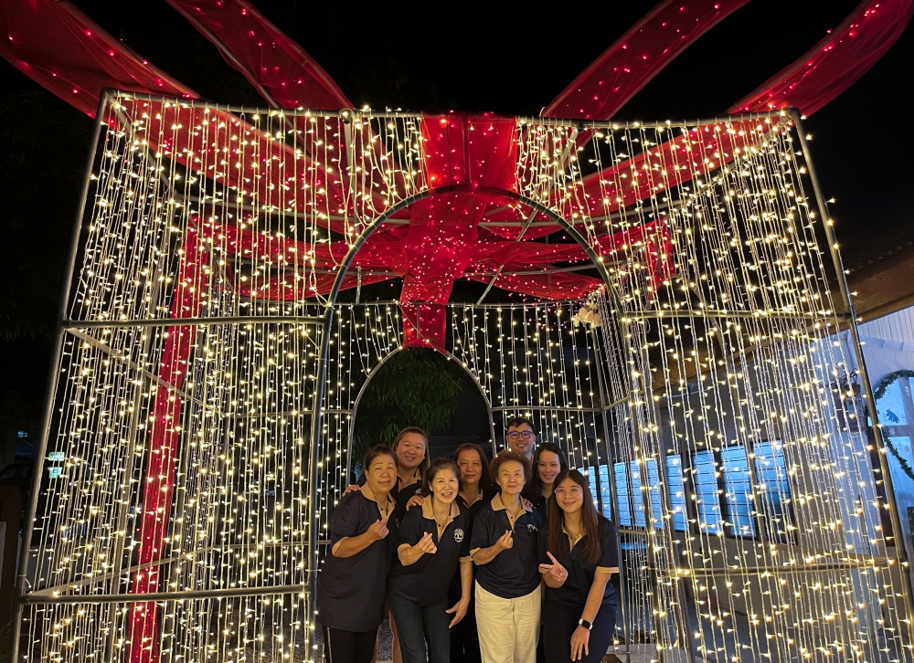 Presbyterian Church committee members pose with a giant gift-box replica illuminated by hundreds of LED lights in the church courtyard in Gua Musang December 24, 2025. — Bernama pic