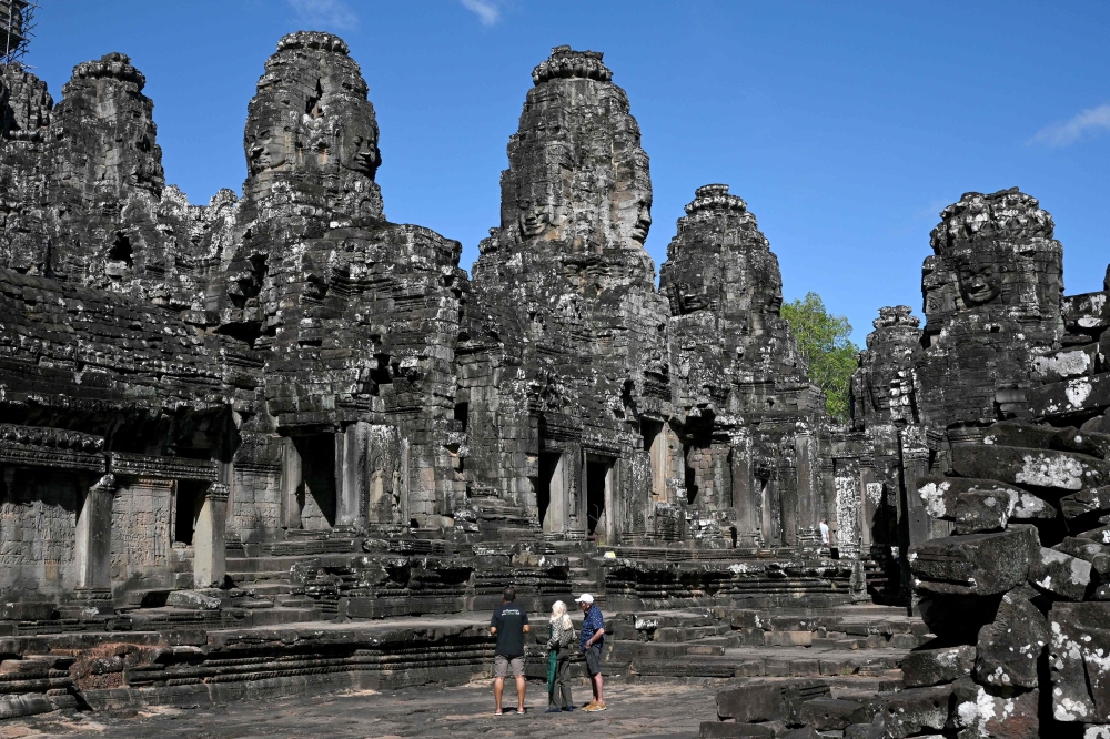 Tourists take selfies as they visit the Bayon temple in Siem Reap province December 18, 2025. — AFP pic