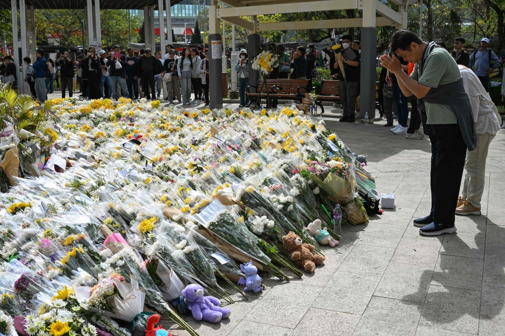 People lay flowers outside the Wang Fuk Court apartment blocks in the aftermath of the deadly November 26 fire in Hong Kong’s Tai Po district December 1, 2025. — AFP pic