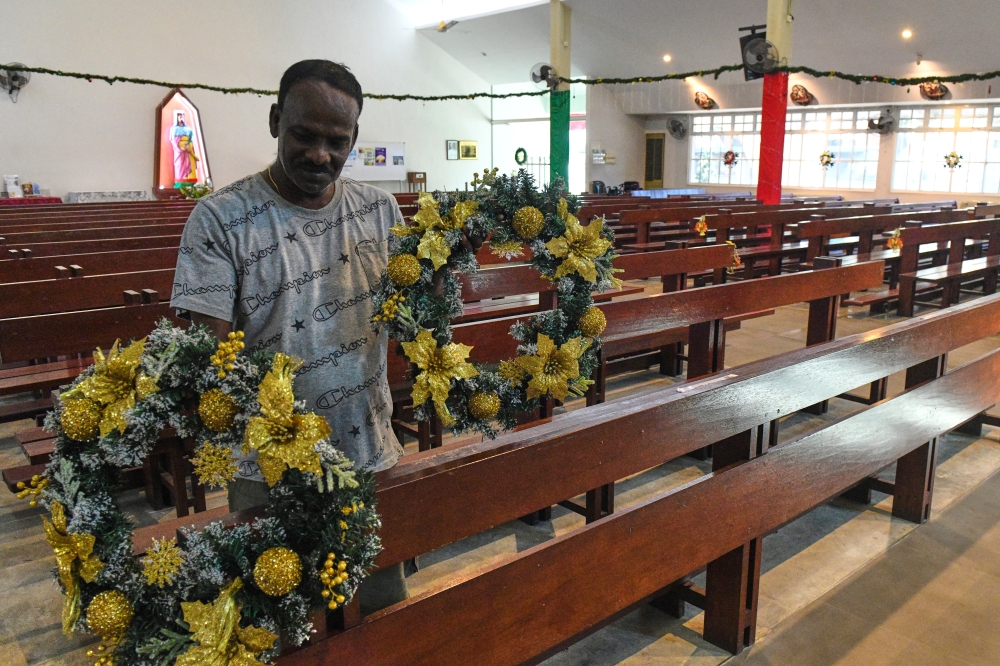 A. Santhana Samy, 58, decorates St. John Britto Church in Sungai Pinang December 24, 2025, as part of the final preparations for Christmas tomorrow. — Bernama pic
