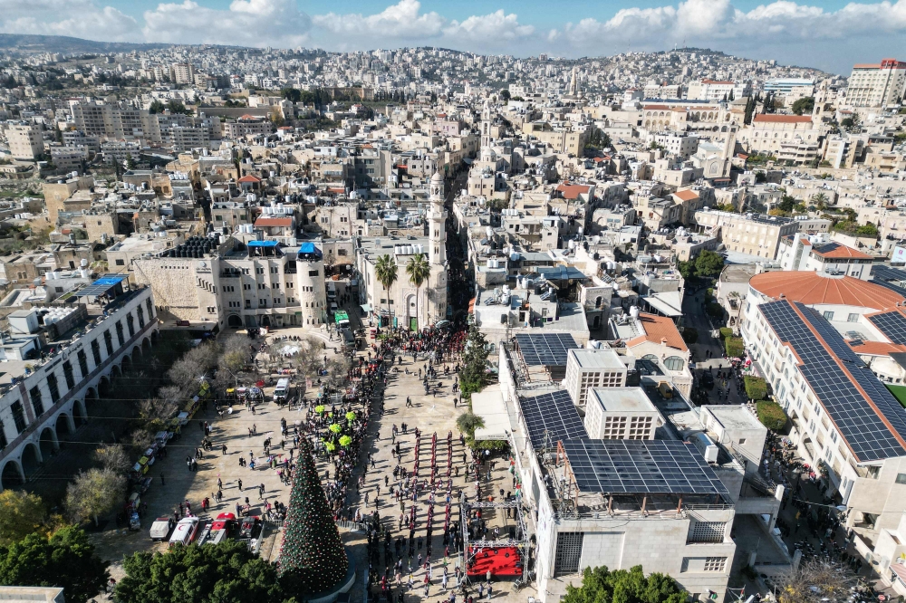 An aerial view shows scouts marching during Christmas eve celebrations on Manger Square outside the Church of the Nativity (unseen) in Bethlehem, in the Israeli-occupied West Bank, on December 24, 2025. — AFP pic