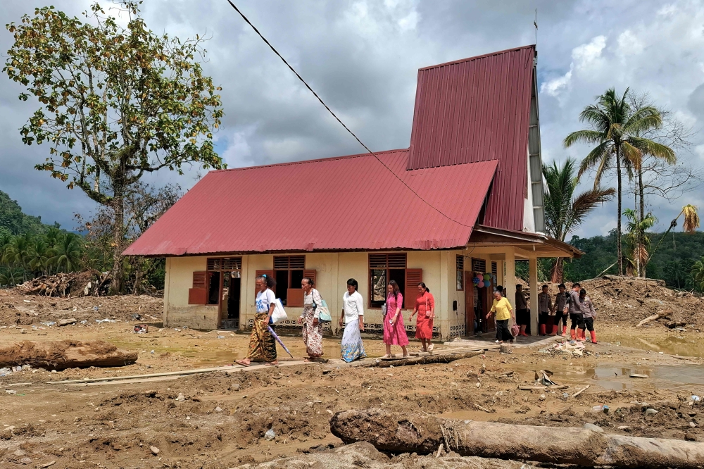 Villagers leave the Angkola Protestant Church at Aek Ngadol village, South Tapanuli, North Sumatra province, on Christmas Day December 25, 2025, in the aftermath of massive flooding and landslides in the area. — AFP pic