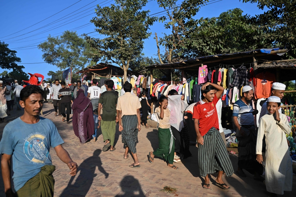 Rohingya refugees walk along a market at the Kutupalong refugee camp in Bangladesh’s Ukhia December 18, 2025. — AFP pic