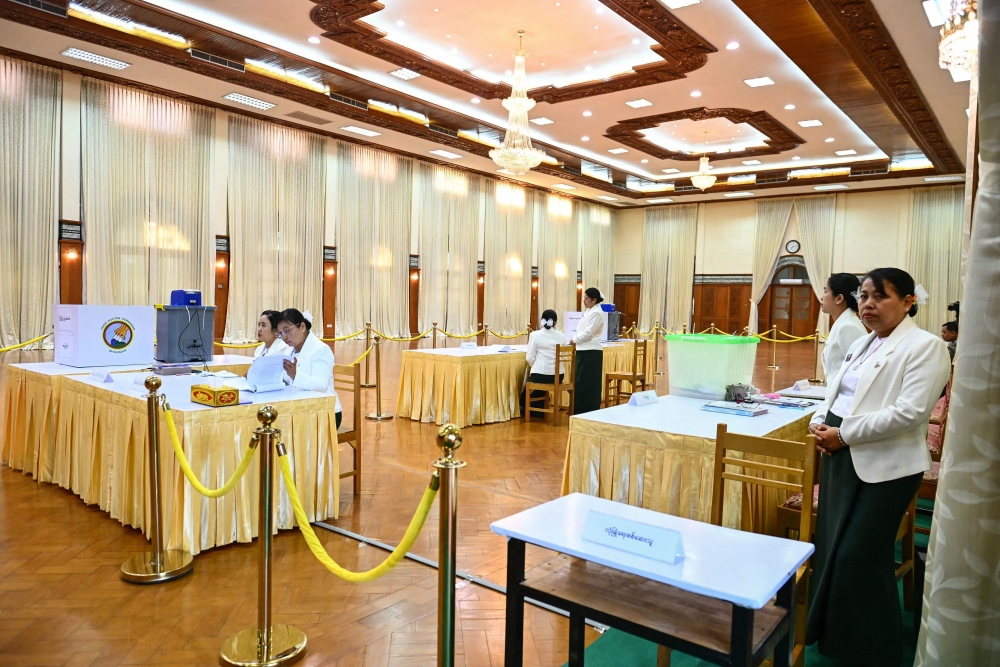 Members of Myanmar’s Union Election Commission wait for voters at a polling station during the first phase of Myanmar’s general election in Naypyidaw on December 28, 2025. — AFP pic