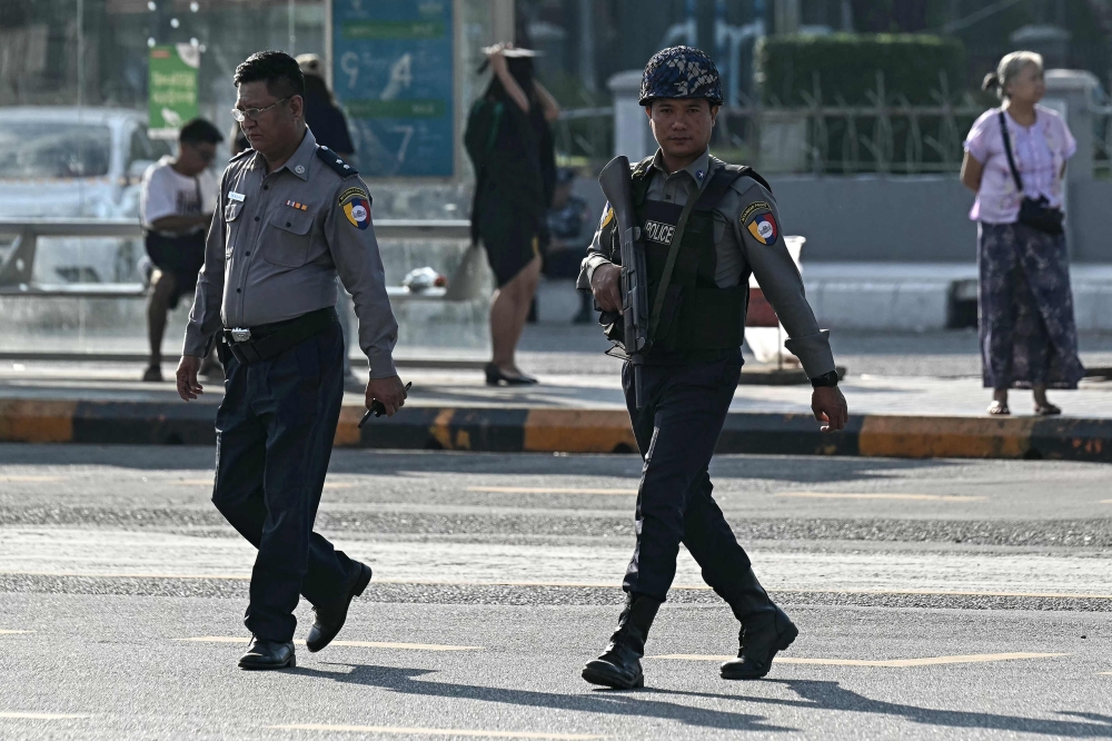 Police officers patrol a street during the first phase of Myanmar’s general election in Yangon on December 28, 2025. — AFP pic
