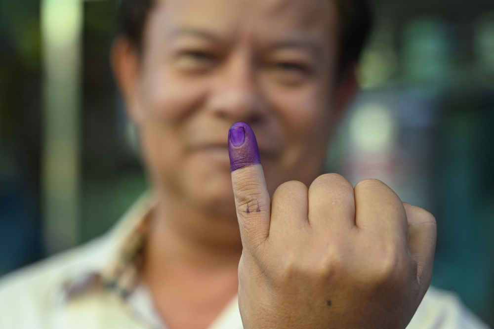 A man shows his inked finger after voting at a polling station in Yangon during the first phase of Myanmar’s junta-run election on December 28, 2025. — AFP pic