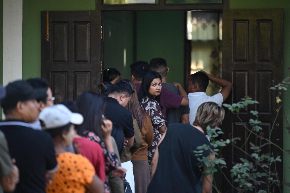 Voters wait in line at a polling station during the first phase of Myanmar's general election in Naypyidaw today. — AFP pic
