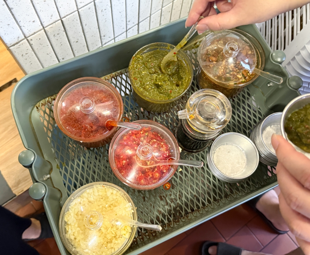 A small selection of chopped garlic, chillies, soy sauce mixed with chillies and two types of chilli sauce is available. 