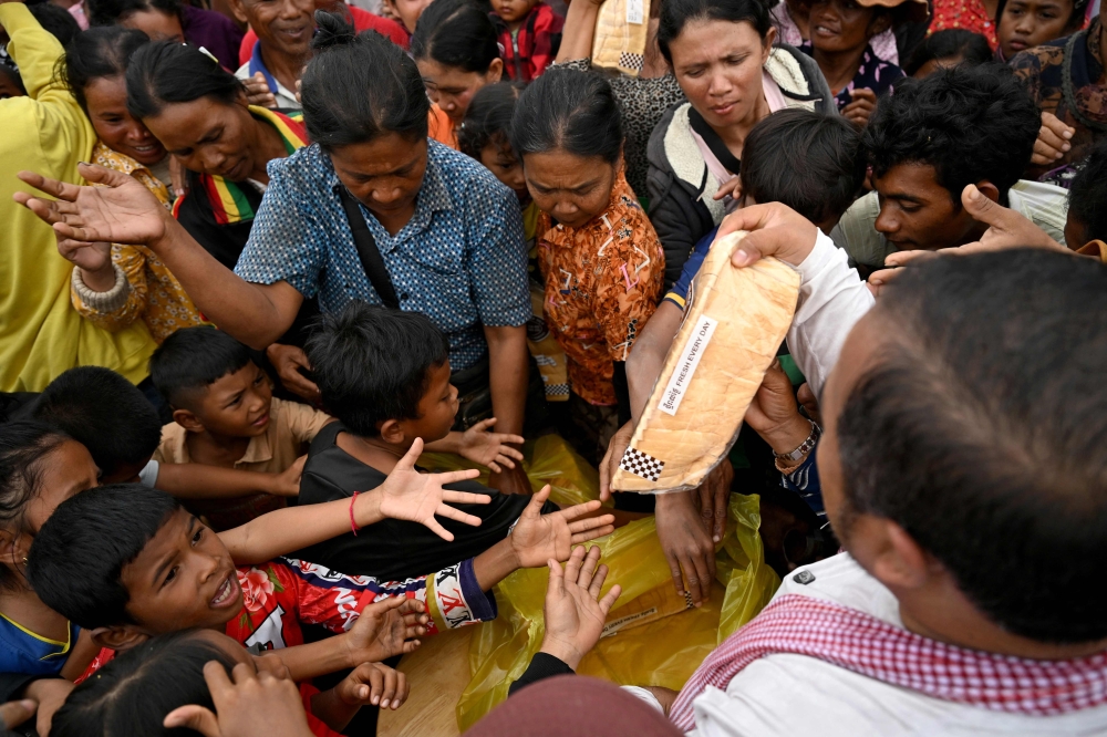 Residents gather to receive aid at a temporary camp in Cambodia's Siem Reap province following border clashes with Thailand and are hesitant to return home for fear the ceasefire, signed on December 27, 2025, may not hold. — AFP pic