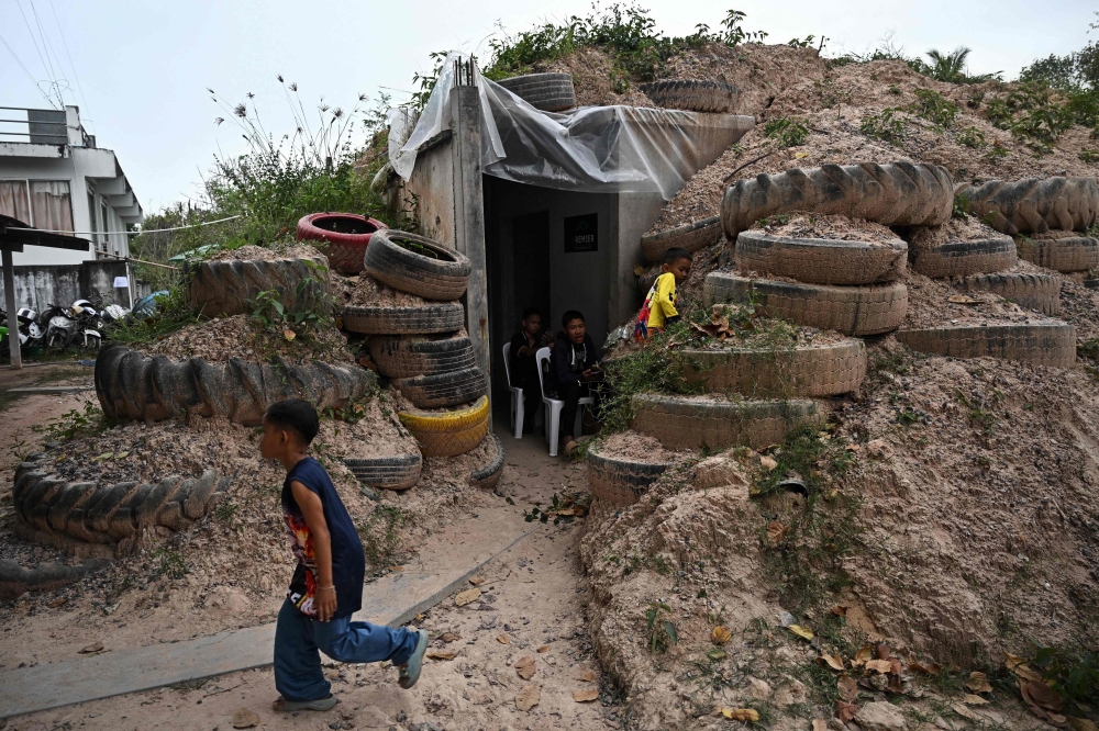 Children play around a bunker in Thailand’s Surin province on December 10, 2025 amid border clashes with Cambodia. A ceasefire was signed on December 27, 2025 but evacuees fear it may be temporary. — AFP pic