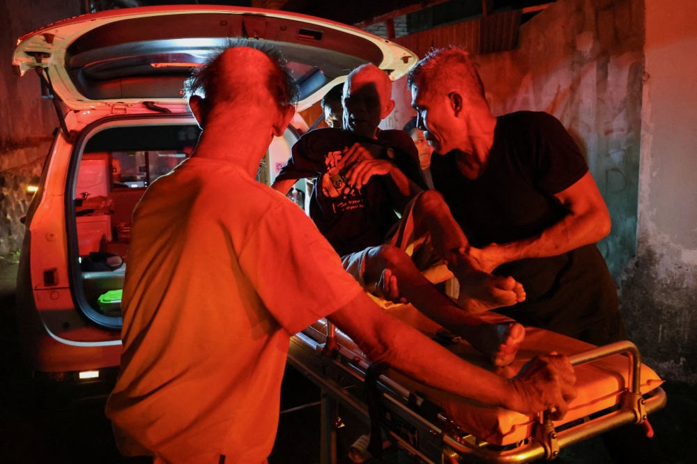 Local people rescue an elderly man during a fire at Werdha Damai retirement home in Manado, North Sulawesi Province, December 28, 2025. — Reuters pic