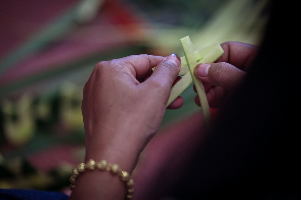 Visitors to the Festival Irama Asli & Asal 2025 in Kuala Lumpur learn how to weave coconut leaves into a ‘tempok’, a traditional Orang Asli headpiece. — Bernama pic
