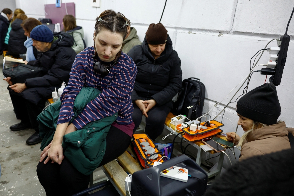Residents charge their devices inside a support point, situated in a bomb shelter, during a long power blackout after critical civil infrastructure was hit by a Russian missile and drone strikes, in the town of Vyshhorod in Kyiv region, Ukraine, December 29, 2025. — Reuters pic