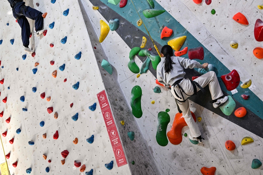 Estella, 14, a homeschooled student, climbs in an indoor rock climbing in Shanghai November 25, 2025. — AFP pic