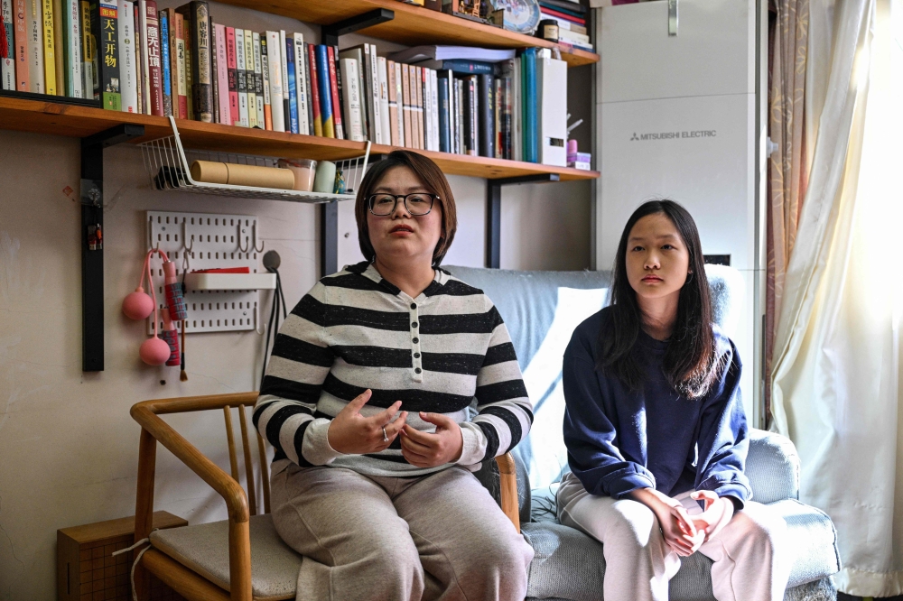 Estella, 14, a homeschooled student, sits next to her mother Xu Zoe, 40, during an interview with AFP in her home in Shanghai November 25, 2025. — AFP pic