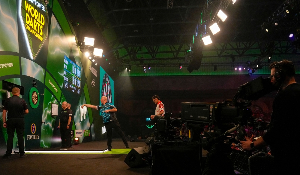 England’s Rob Cross throws during his match against Australia’s Damon Heta at the World Darts Championship at Alexandra Palace in London December 28, 2025. — AFP pic