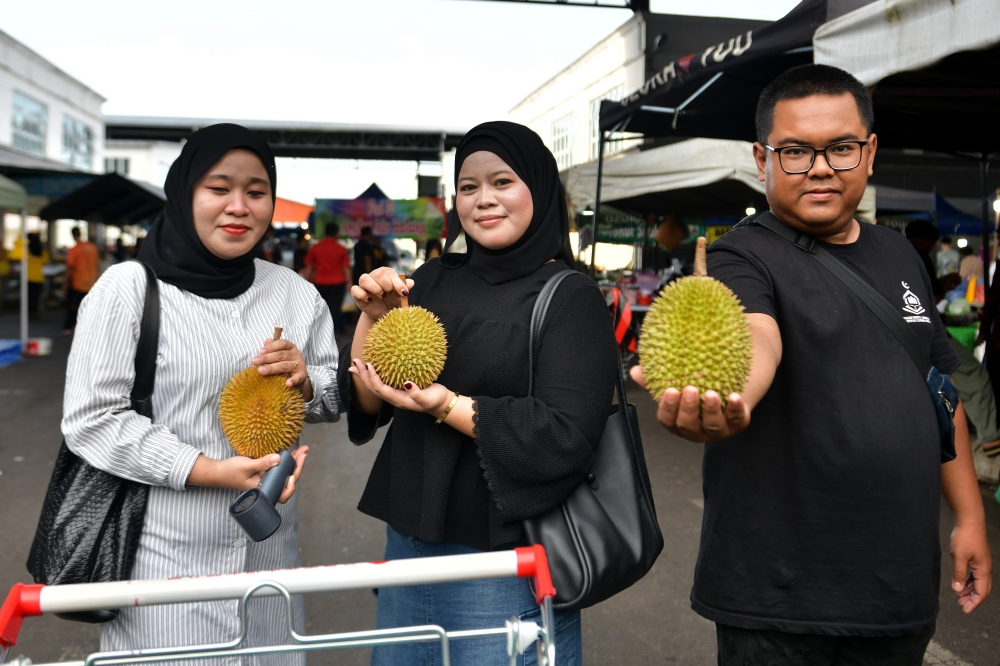 Customers show off their durian haul after snapping up bargain-priced fruits at Demak Farmers’ Market in Kuching December 30, 2025. — Bernama pic