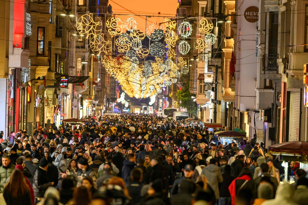 Crowds stroll down Istanbul’s Istiklal Street, aglow with festive lights on New Year’s Eve 2025. — AFP pic