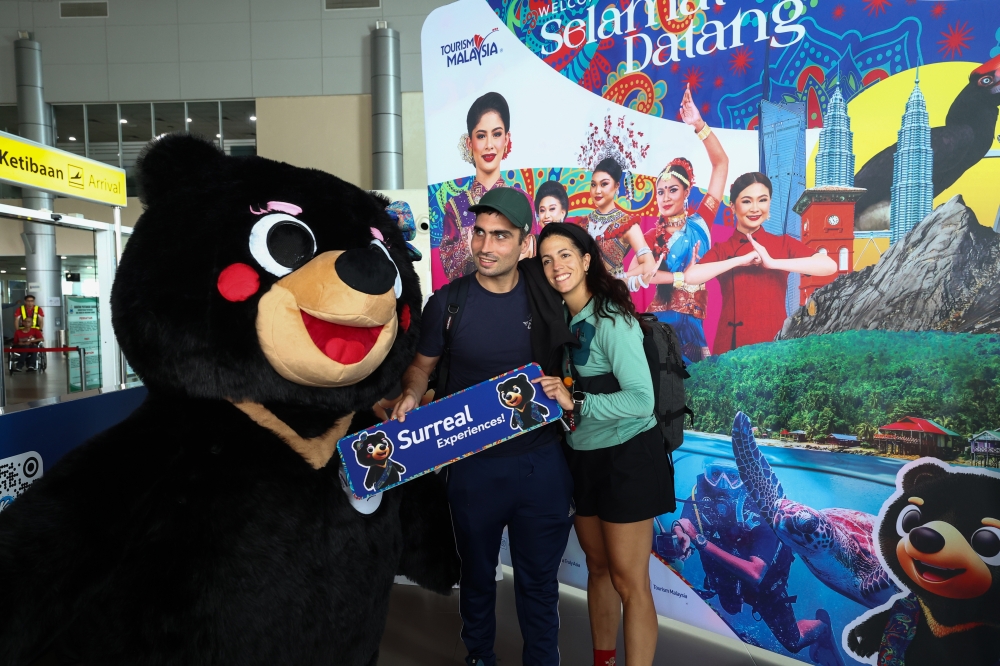Two tourists pose for a photo with Manja, the mascot of Visit Malaysia Year 2026, at a ceremony to welcome the arrival of the earliest visitors in conjunction with the official launch of Visit Malaysia 2026 (VM2026) at Sandakan Airport January 1, 2026. — Bernama pic