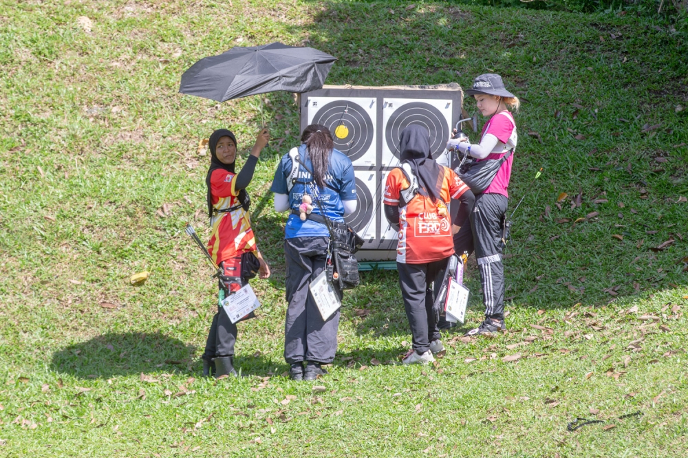 Participants inspect and record their scores at a target during the National Field Archery Championship at Panorama, Bukit Antarabangsa, Hulu Kelang, Ampang December 20, 2025. — Picture by Raymond Manuel