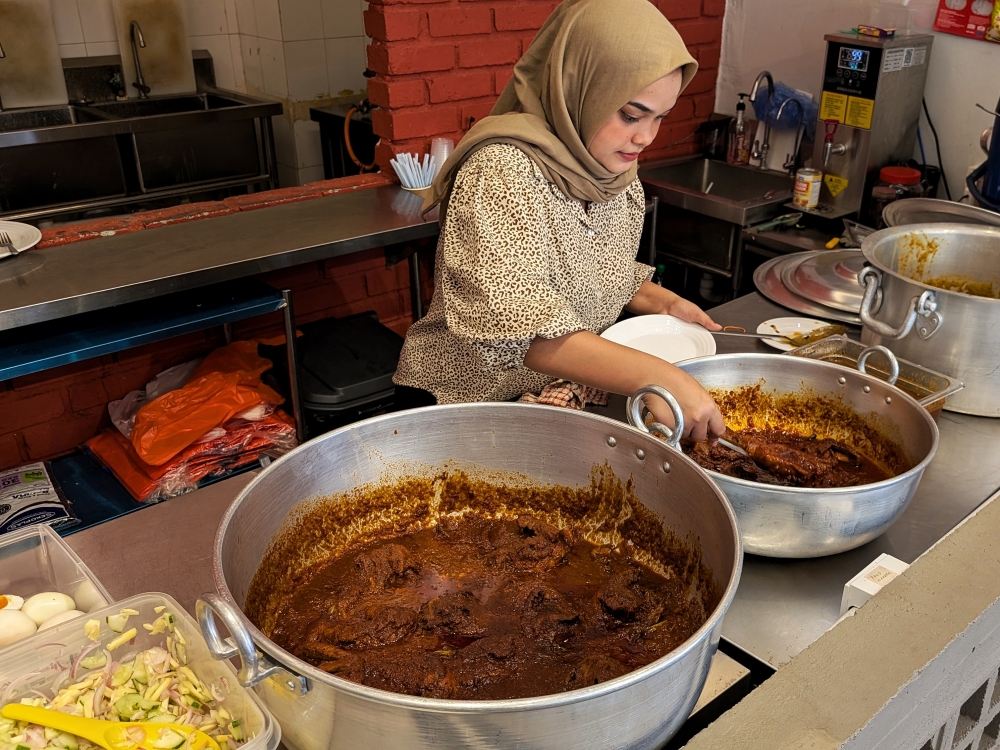The spread of main dishes on our visit included ‘ayam bawang’, ‘ayam Tanjung’, ‘daging’ and a large pot of ‘kuah dalca’. — Picture by Ethan Lau