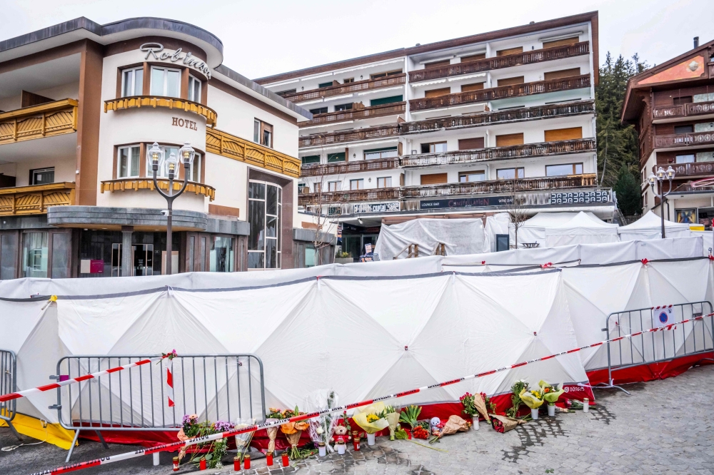 This photograph shows flowers and candles laid near the bar Le Constellation where a fire ripped through the venue during New Year's Eve celebrations in the Alpine ski resort town of Crans-Montana killing around 40 people and injuring more than 100 others, in Crans-Montana on January 2, 2026. — AFP pic 