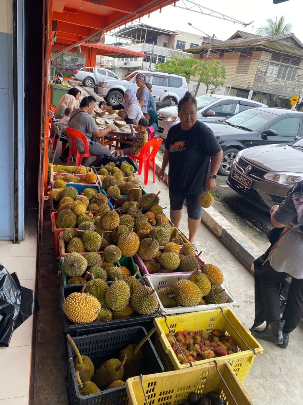 Customers enjoy durians at the Brainman Farm shop in Marudi. — Picture via Facebook/Mujan Lah