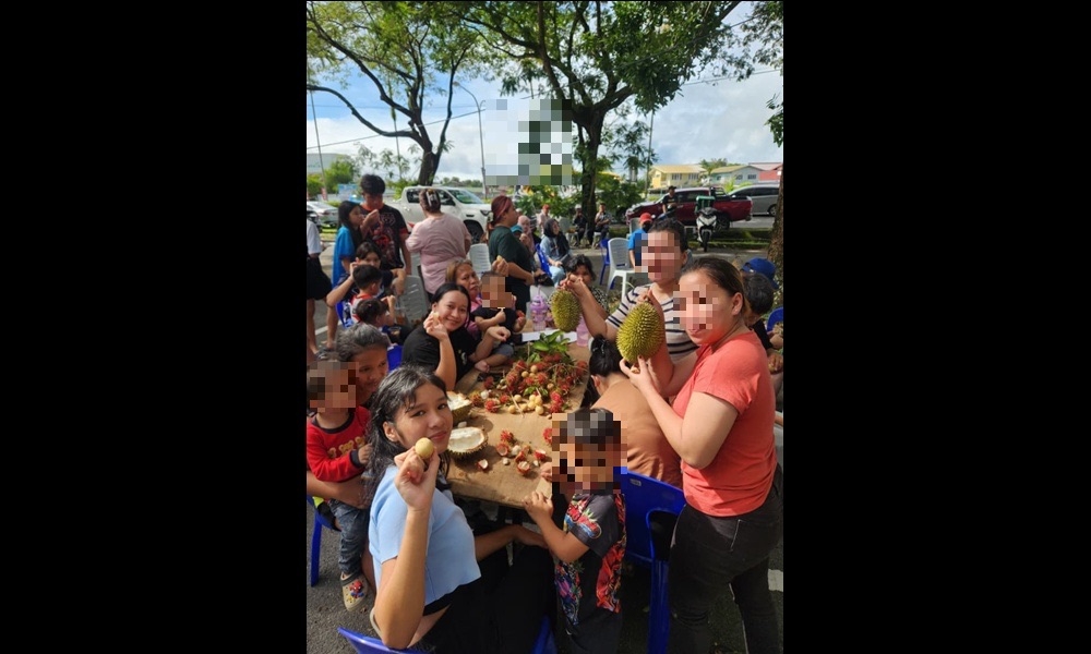 A family enjoys durians and rambutans during the event. — The Borneo Post pic