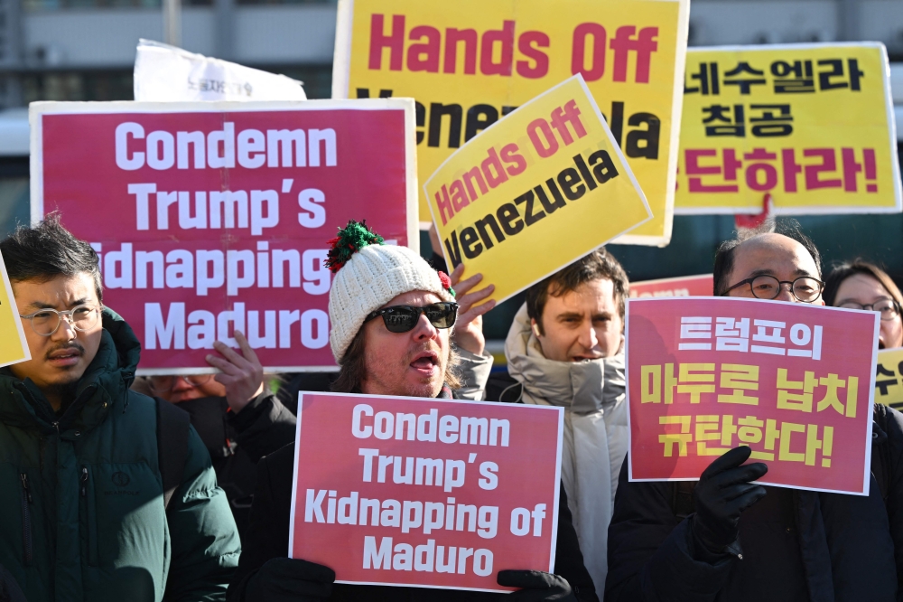 Protesters hold placards during a demonstration condemning the US attack on Venezuela and the seizure of Venezuelan leader Nicolas Maduro in front of the US embassy in Seoul on January 5, 2026. — AFP pic
