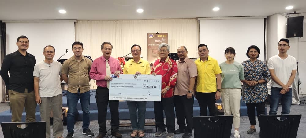 Lo (5th left) and church members during the symbolic handover of the Unifor funds. — The Borneo Post pic