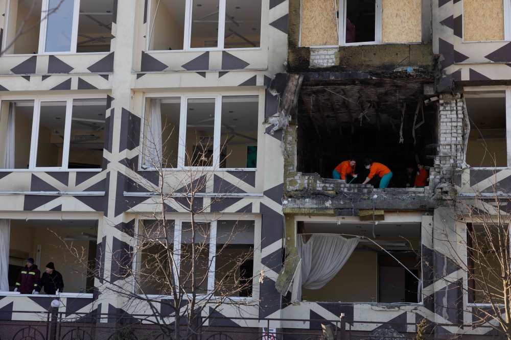 People clear debris in a damaged private medical clinic following a drone strike in Kyiv, on January 5, 2026, amid the Russian invasion in Ukraine. — AFP pic