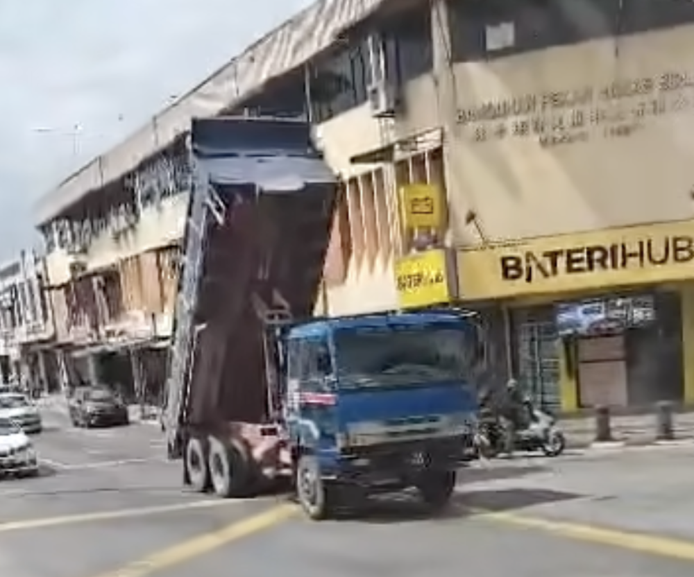 The sand lorry with its rear bucket raised, moments before it struck an electrical cable connected to a traffic light in Pekan Nanas.